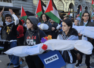 New Zealand pro-Palestine protesters in Auckland carry mock "bodies" today representing Gazan journalists killed by the Israeli military