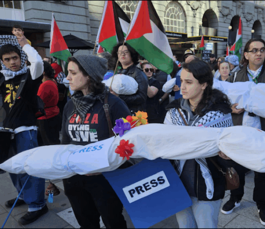 New Zealand pro-Palestine protesters in Auckland carry mock "bodies" today representing Gazan journalists killed by the Israeli military
