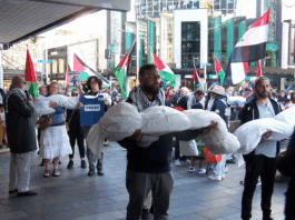 New Zealand protesters over the Israeli killings of Palestinian journalists in Gaza carry symbolic bodies