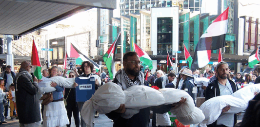 New Zealand protesters over the Israeli killings of Palestinian journalists in Gaza carry symbolic bodies