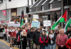 Placards declare "Zionism a threat to humanity" and "Let Gaza live"