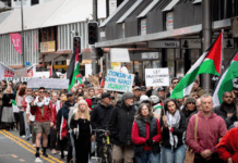 Placards declare "Zionism a threat to humanity" and "Let Gaza live"