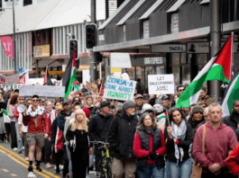 Placards declare "Zionism a threat to humanity" and "Let Gaza live"