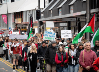 Placards declare "Zionism a threat to humanity" and "Let Gaza live"