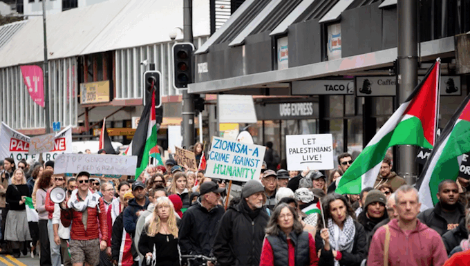 Placards declare "Zionism a threat to humanity" and "Let Gaza live"
