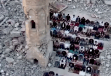Palestinians perform prayer next to the rubble of a mosque that was destroyed by the Israeli occupation forces during the Gaza genocide