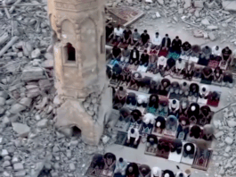 Palestinians perform prayer next to the rubble of a mosque that was destroyed by the Israeli occupation forces during the Gaza genocide