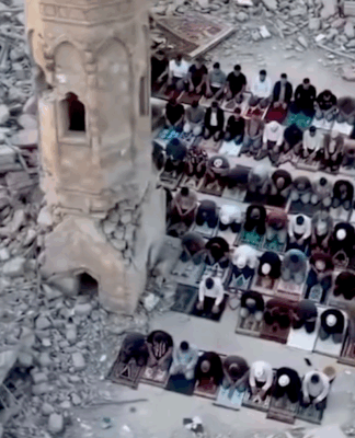 Palestinians perform prayer next to the rubble of a mosque that was destroyed by the Israeli occupation forces during the Gaza genocide