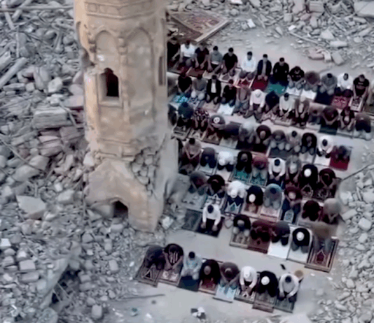 Palestinians perform prayer next to the rubble of a mosque that was destroyed by the Israeli occupation forces during the Gaza genocide