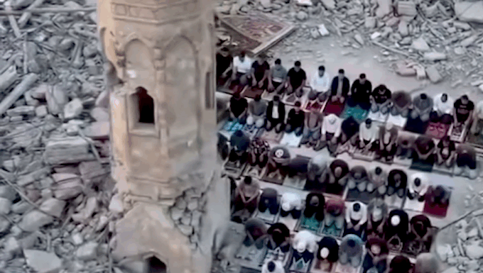 Palestinians perform prayer next to the rubble of a mosque that was destroyed by the Israeli occupation forces during the Gaza genocide
