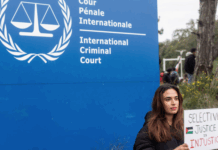 A demonstrator holds a sign reading, "Selective Justice is Injustice"