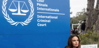 A demonstrator holds a sign reading, "Selective Justice is Injustice"