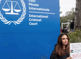 A demonstrator holds a sign reading, "Selective Justice is Injustice"