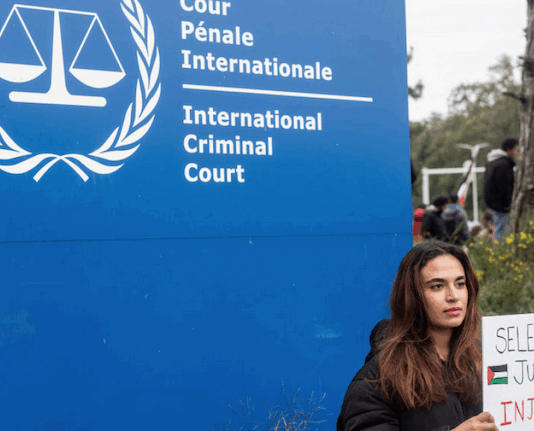 A demonstrator holds a sign reading, "Selective Justice is Injustice"