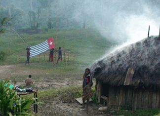 A West Papuan Morning Star flag being held in defiance of the Indonesian ban in a remote village