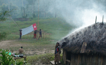 A West Papuan Morning Star flag being held in defiance of the Indonesian ban in a remote village