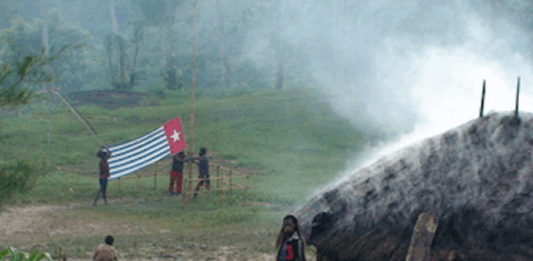 A West Papuan Morning Star flag being held in defiance of the Indonesian ban in a remote village