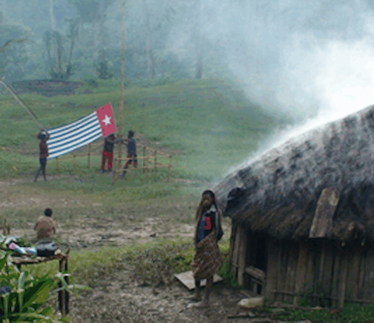 A West Papuan Morning Star flag being held in defiance of the Indonesian ban in a remote village