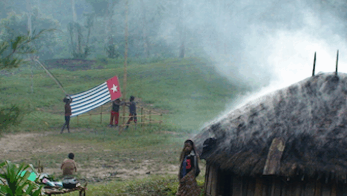 A West Papuan Morning Star flag being held in defiance of the Indonesian ban in a remote village
