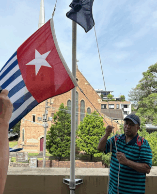 West Papuan liberation fighters risk ‘extermination’ by Indonesia’s high-tech forces West Papuan supporters raise the Morning Star flag in Leichhardt, Sydney, today as protesters around the world mark the 1 December 1961 "independence" flag-flying day. Image: AWPA