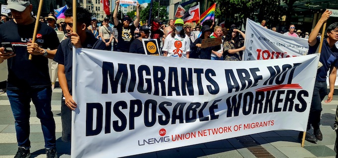 "Immigrants are not disposable" banner at the Toitū Te Aroha rally