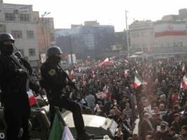 Iranian security forces keep watch on a rally in Tehran.