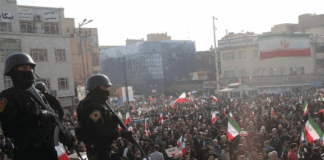 Iranian security forces keep watch on a rally in Tehran.
