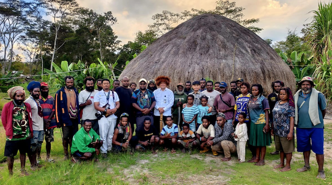 Laurens Ikinia (standing in centre of the Papuan group)