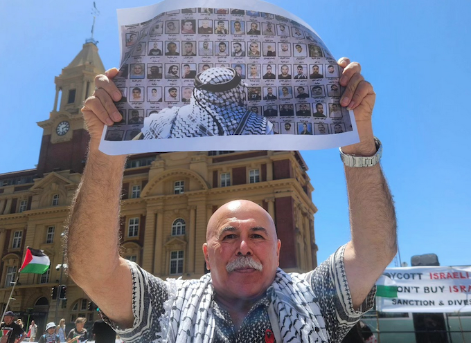 Protester Dr Faiez Idais holds up photographs of some of the thousands of Palestinian detainees held in Israeli prisons
