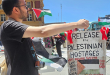 A "release the Palestinian hostages" placard at today's Red Ribbon Campaign protest