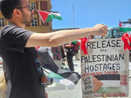 A "release the Palestinian hostages" placard at today's Red Ribbon Campaign protest