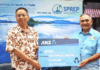 China's ambassador to Samoa Fei Mingxing (left) hands over a ceremonial cheque for US$200,000 to SPREP director of legal services and governing bodies Aumua Clark Peteru in Apia