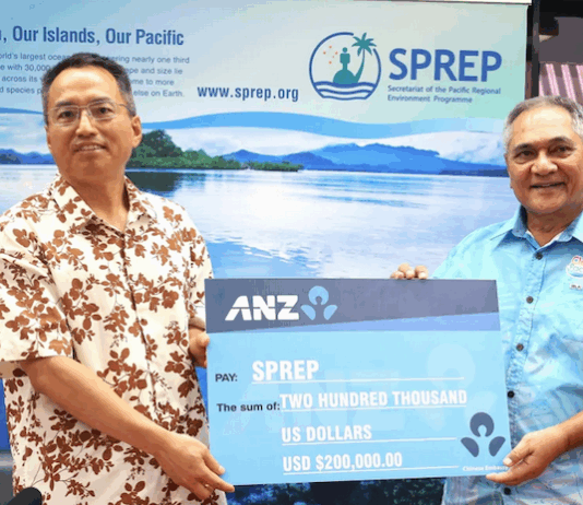China's ambassador to Samoa Fei Mingxing (left) hands over a ceremonial cheque for US$200,000 to SPREP director of legal services and governing bodies Aumua Clark Peteru in Apia
