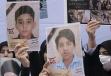 Iranian women hold photos of children who are killed by US-Israeli attacks, including a massacre at a Minab girls’ school that killed around 175 people
