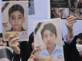 Iranian women hold photos of children who are killed by US-Israeli attacks, including a massacre at a Minab girls’ school that killed around 175 people