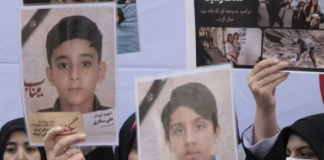 Iranian women hold photos of children who are killed by US-Israeli attacks, including a massacre at a Minab girls’ school that killed around 175 people