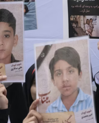 Iranian women hold photos of children who are killed by US-Israeli attacks, including a massacre at a Minab girls’ school that killed around 175 people