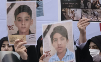 Iranian women hold photos of children who are killed by US-Israeli attacks, including a massacre at a Minab girls’ school that killed around 175 people