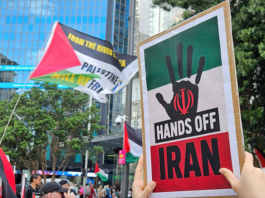 A "Hands Off Iran" placard at the Auckland rally