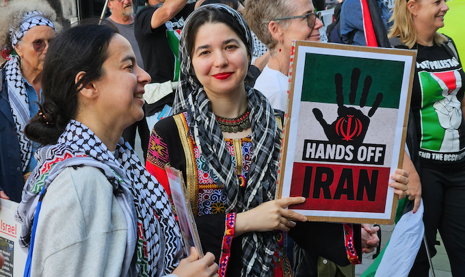 Two women protesters with a "Hands off Iran" placard