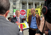 Opposition Labour leader Chris Hipkins (left) receives the Iran war petition from Greenpeace executive director Dr Russel Norman