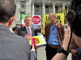 Opposition Labour leader Chris Hipkins (left) receives the Iran war petition from Greenpeace executive director Dr Russel Norman