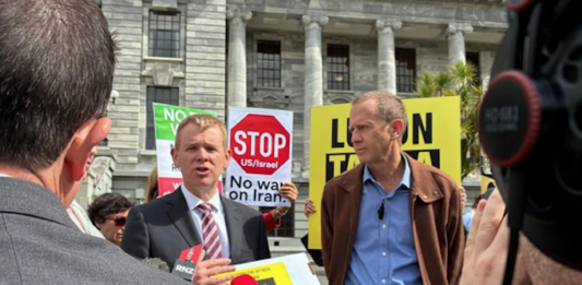 Opposition Labour leader Chris Hipkins (left) receives the Iran war petition from Greenpeace executive director Dr Russel Norman