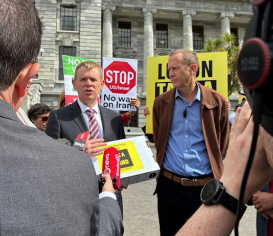 Opposition Labour leader Chris Hipkins (left) receives the Iran war petition from Greenpeace executive director Dr Russel Norman