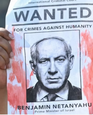 A woman protester holds up a “Wanted” poster featuring Israel’s Prime Minister Benjamin Netanyahu