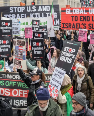 Protesters wave flags and banners reading “Stop Bombing Iran” and “Stop Bombing the Middle East” as they gather at Victoria Tower Gardens in London