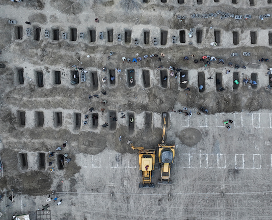 Mourners dig graves for the funeral of 170 children killed in a US-Israeli strike on a primary school