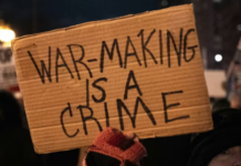 ‘Maniacal tyrant’ Trump and Iran trade threats to energy infrastructure over Strait of Hormuz A US protester holds placards reading ‘’war making is a crime’’