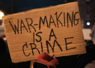 A US protester holds placards reading ‘’war making is a crime’’