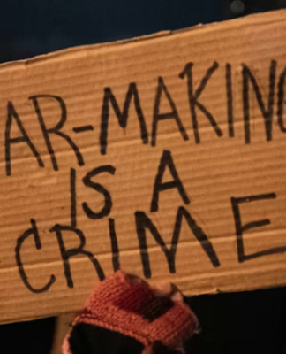 A US protester holds placards reading ‘’war making is a crime’’